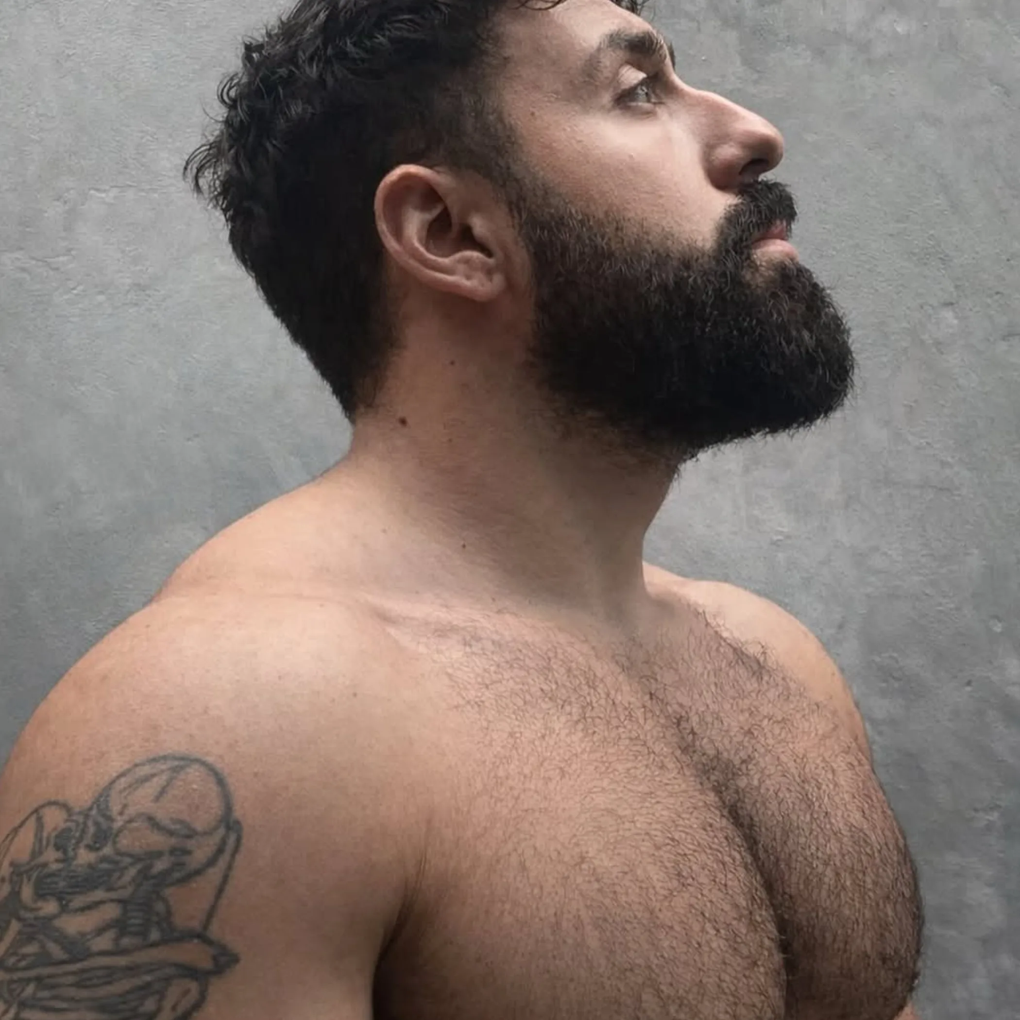man with beard touching face