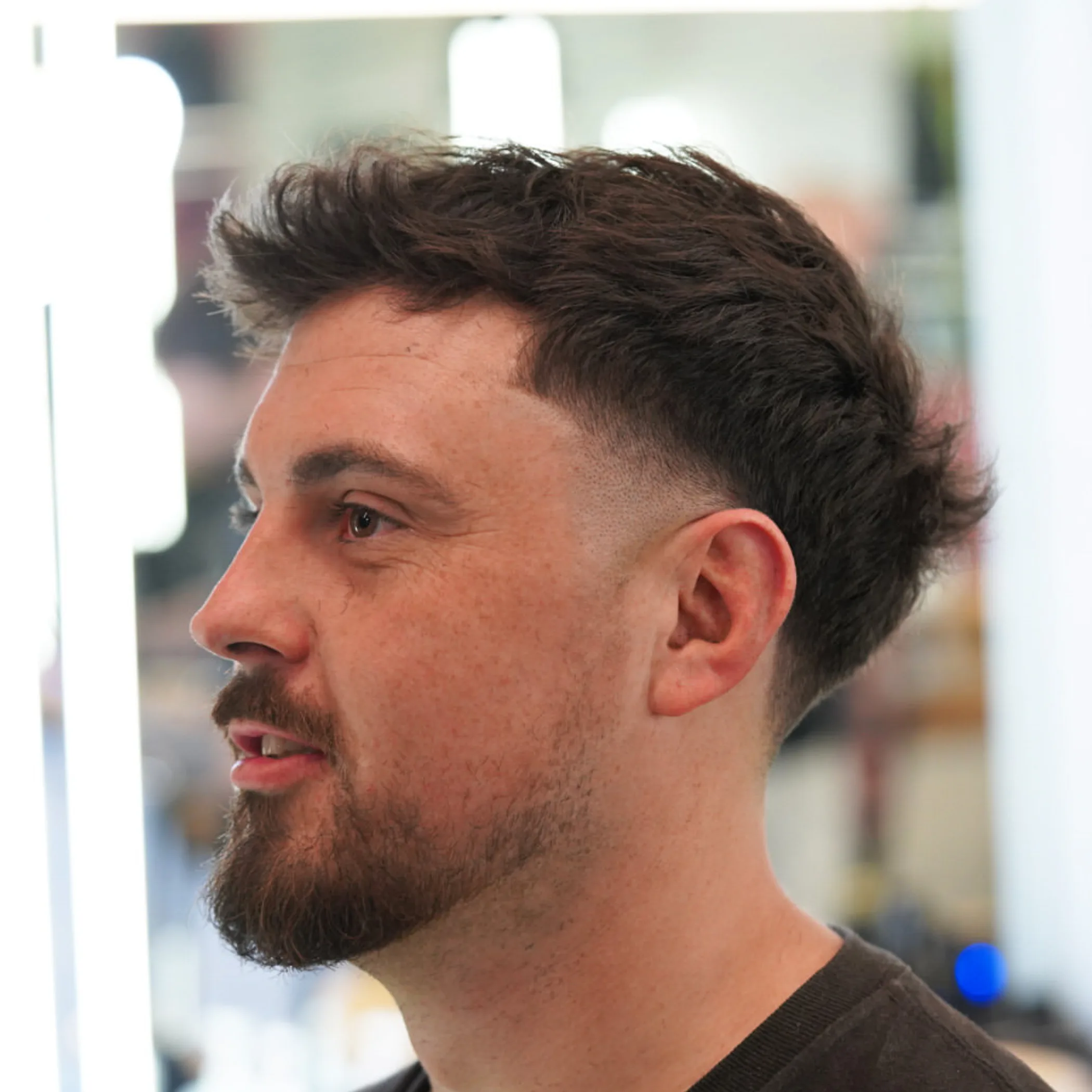 man grooming beard with trimmer